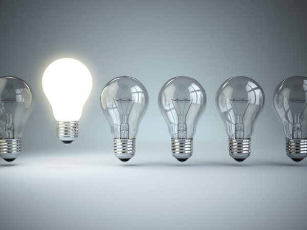 Idea or uniqueness, originality concept. Row of light bulbs with glowing one. 3d